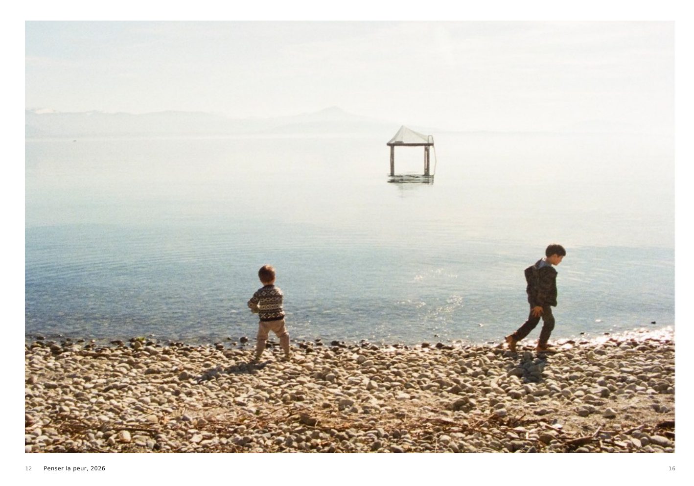 Penser la peur, 2026, two children walking along a beach beside Lake Geneva