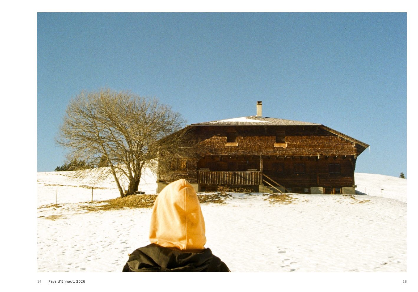 Pays d’Enhaut, 2026, a veiled figure seated in snow before a chalet