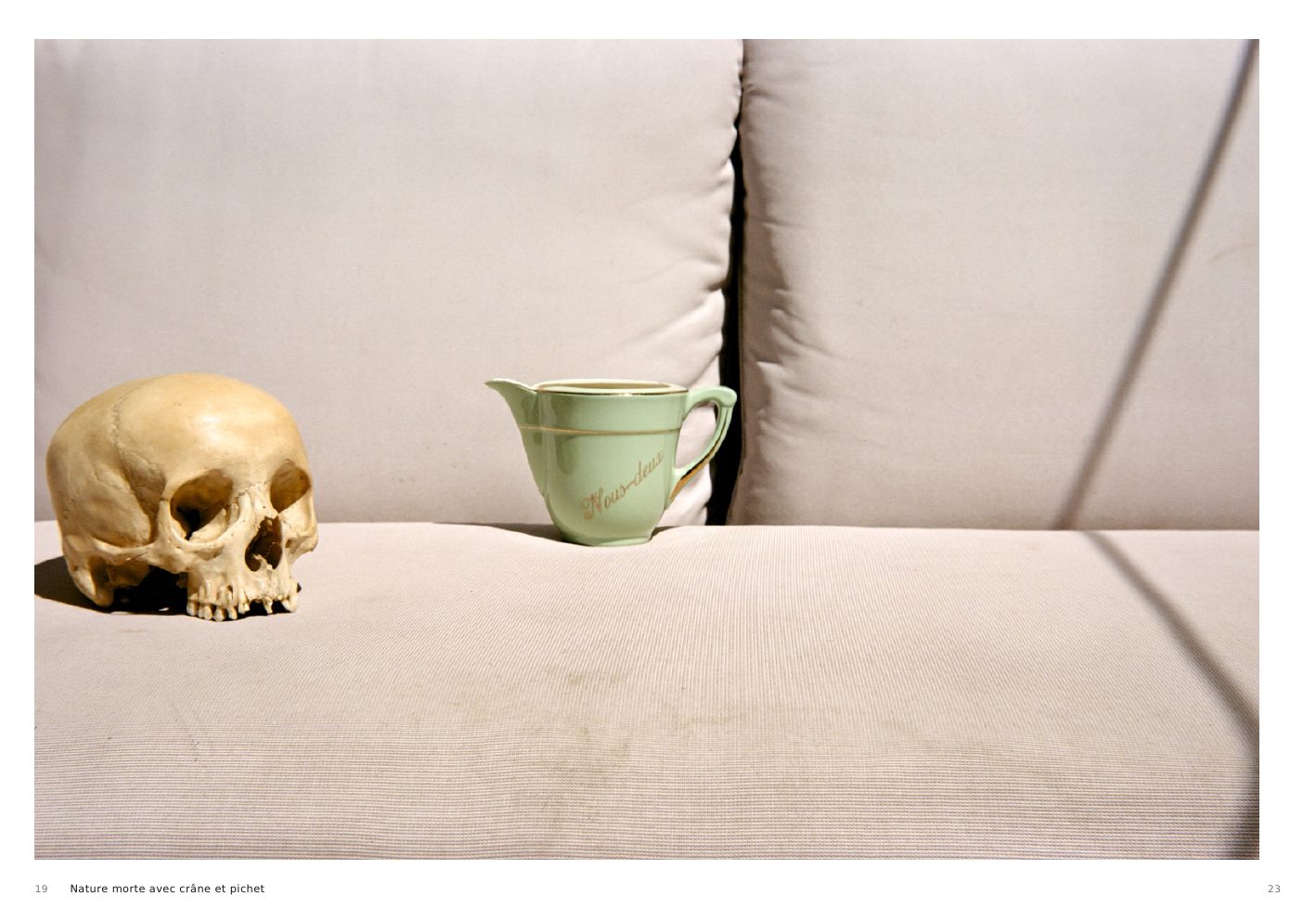 Nature morte avec crâne et pichet, a skull and green jug on a pale sofa